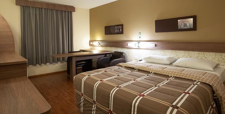 duas camas de casal em frente a uma televisão em um quarto do Hotel 10 duas camas de casal em frente a uma televisão em um quarto do Hotel 10