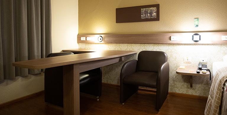 uma poltrona preta em um escritório em anexo ao quarto de um hotel 10 uma poltrona preta em um escritório em anexo ao quarto de um hotel 10