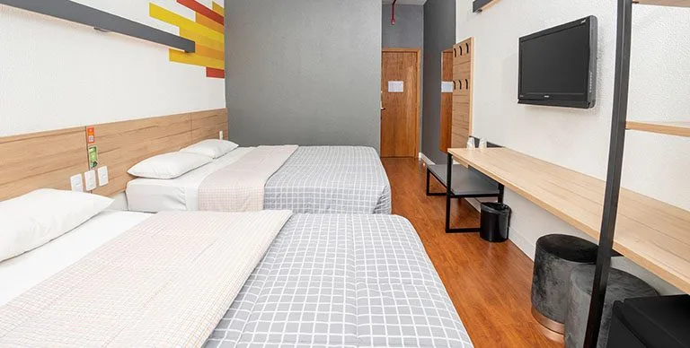 duas-camas-de-casal-em-frente-a-uma-televisao-em-um-quarto-do-Hotel-10-n-qr6zoy5b7ta3da7xai68ctsxspp